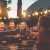 a group of people sitting at a table with food and lights