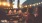 a group of people sitting at a table with food and lights