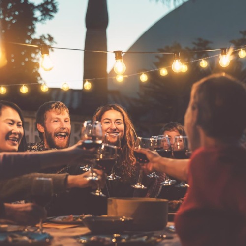 Find your perfect fit at Revel Greensboro a group of people sitting at a table with food and lights