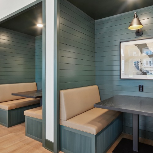 Coworking Lounge  A room with grey tables and beige chairs.