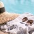 A hat and a pair of sunglasses next to a pool.