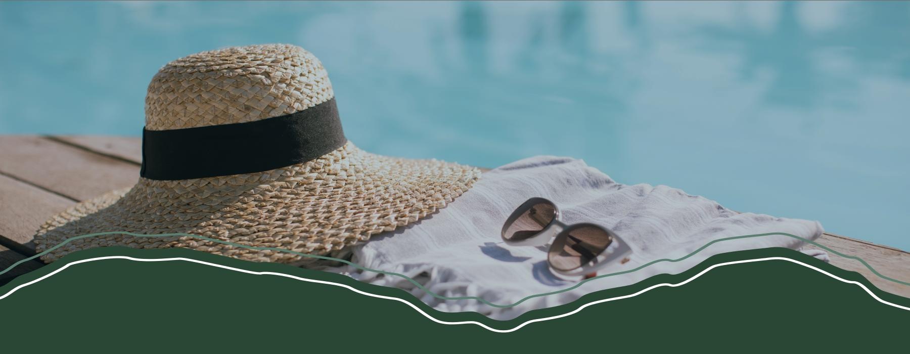 a hat and sunglasses by a pool